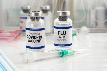 Photo for Coronavirus vaccine bottles and Flu Shot vaccine for booster vaccination for new variants of Sars-cov-2 virus and Influenza A. Flu A-B and Covid-19 vaccine vials for booster shot for omicron and Influenza virus - Royalty Free Image