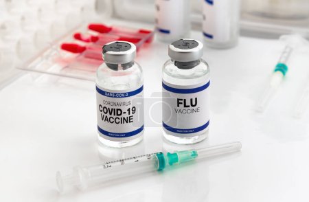Photo for Coronavirus vaccine and Flu vials vaccine for booster vaccination for new variants of Sars-cov-2 virus and Influenza A. Flu and Covid-19 vaccine ampoules for booster shot for Influenza virus and covid omicron - Royalty Free Image
