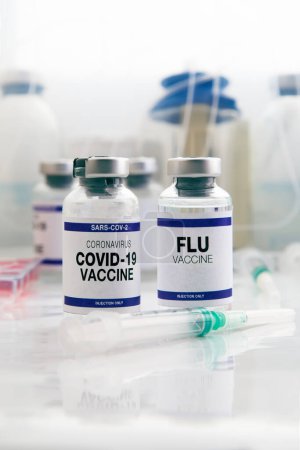Foto de Vacuna contra el Coronavirus y Vacuna antigripal para la vacunación de nuevas variantes de los virus Sars-cov-2 e Influenza. Viales de vacuna contra la gripe y el covid-19 para la inyección de recuerdo para el virus de la gripe y el covidio - Imagen libre de derechos