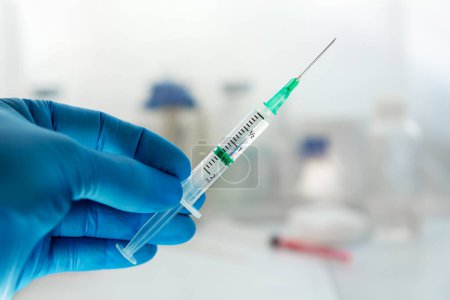 Photo for Physician holding syringe with dose for injection isolated on medical consultation background. Doctor holding a syringe with a needle and with a dose of vaccine or medicine - Royalty Free Image