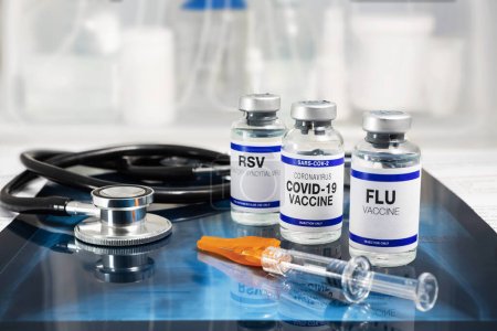 Frascos de vacuna para virus de la gripe, virus respiratorio sincitial y covid-19 para vacunación. Viales de vacuna contra la gripe, el VRS y el coronavirus Sars-cov-2 sobre radiografía pulmonar con estetoscopio