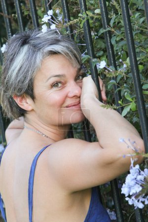 Foto de Retrato de mujer con flores en el jardín - Imagen libre de derechos