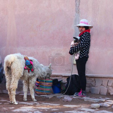 Photo for Woman with a cute baby goat in a  hat  with alpaca - Royalty Free Image