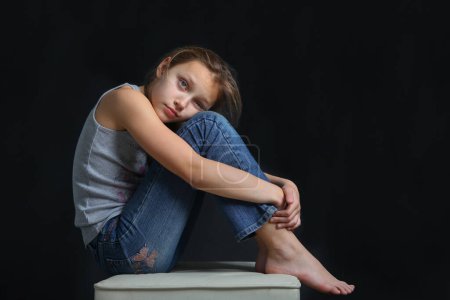Foto de Retrato de niña preadolescente triste sobre fondo negro - Imagen libre de derechos