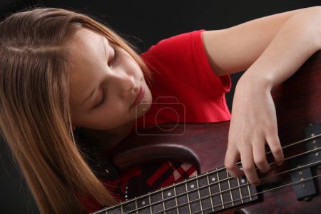 Photo for Preteen girl playing bass guitar - Royalty Free Image