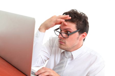 estresado hombre con gafas sobre fondo blanco mirando a la pantalla del ordenador portátil en la desesperación 