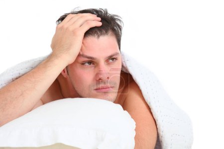 close up portrait of frustrated upset young man in bed on white background