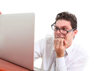 stressed out man with glasses on white background staring at laptop screen in despair 