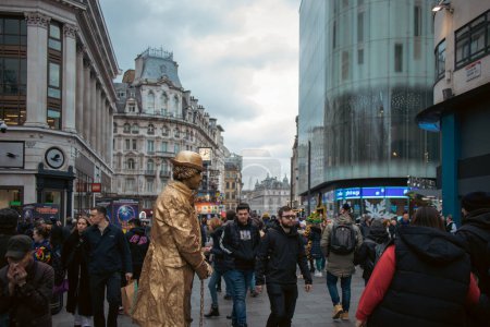 Foto de Londres, 3 de diciembre de 2022 - Artista callejero humano vivo actuando en Leicester Square Christmas Market con transeúntes - Imagen libre de derechos