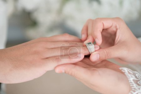 Pareja de boda malaya poniendo un anillo en la mano.Enfoque selectivo y DOF poco profundo.