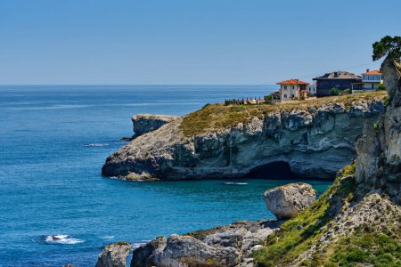Téléchargez les photos : Istanbul, Turkey. The rocky shore of the Black Sea with a cave in Sile, beautiful villas on a hill. Seascape - en image libre de droit