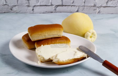 Téléchargez les photos : Certains petits pains au Brésil sont appelés "Bisnaguinha" remplis de fromage et de fromage à la crème sur une assiette blanche. - en image libre de droit