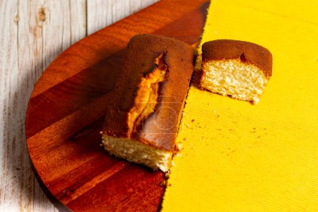Téléchargez les photos : Deux morceaux de gâteau sur une assiette en bois avec un napperon jaune. - en image libre de droit