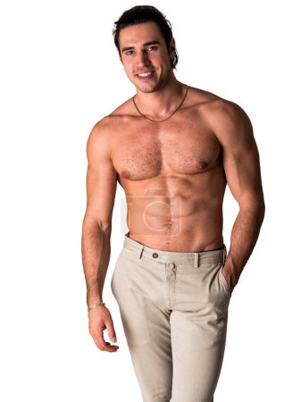 Photo for Three quarters shot of handsome shirtless athletic young man in pants, smiling to camera in studio shot, isolated on white background - Royalty Free Image