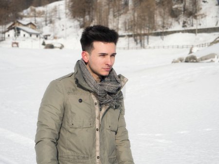 Téléchargez les photos : Young attractive man in the mountain in winter with snow around him - en image libre de droit