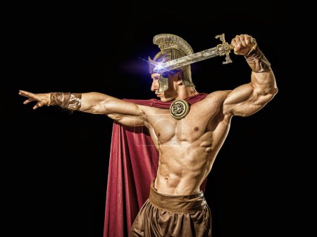 Photo for Young handsome muscular man posing in roman or spartan gladiator costume with shield and sword, isolated on black background in studio - Royalty Free Image