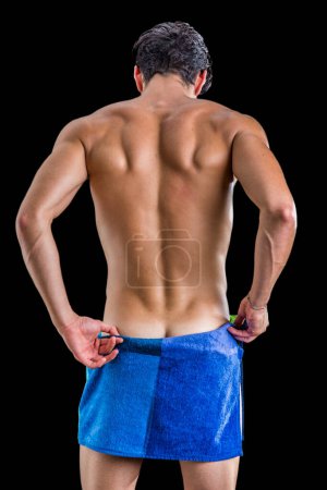 Photo for Back of naked handsome young man with sexy body covering buttocks with a towel - Royalty Free Image
