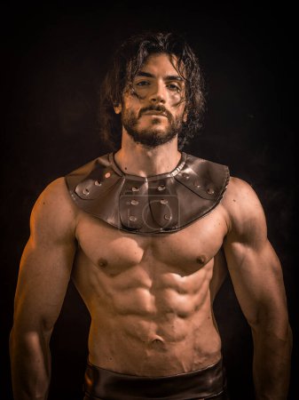 Photo for Young handsome muscular man posing shirtless in roman or spartan gladiator costume in studio - Royalty Free Image