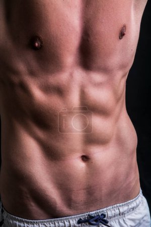 Téléchargez les photos : Un gros plan d'un homme torse nu. Détails du torse, des abdos et des muscles du pec - en image libre de droit