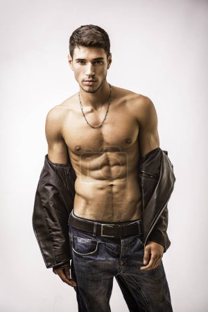 A shirtless man in jeans and a leather jacket