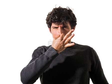 Photo for A man making a funny face with his finger, closing his nose because of foul smell or bad odour - Royalty Free Image