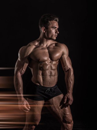 Starke Zurschaustellung von Männlichkeit: Muskeln spielen lassen und Haltung zeigen im Studio. Ein Mann posiert für ein Foto, während er im Studio seine Muskeln spielen lässt
