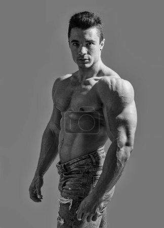 Muscles in Motion: Fesselndes Bild eines attraktiven, hemdslosen männlichen Bodybuilders. Ein Mann ohne Hemd posiert für ein Foto
