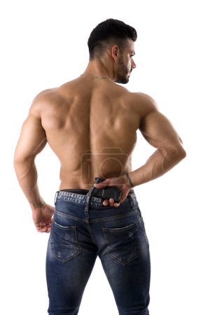 A shirtless muscular man with his back to the camera, holding a gun, isolated on white in studio shot
