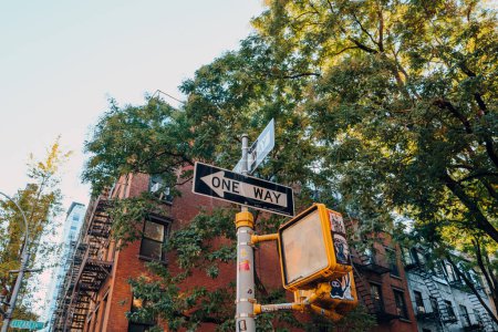 Foto de Nueva York, Estados Unidos - 21 de noviembre de 2022: Vista de ángulo bajo del cartel de One Way en una calle de Nolita, una encantadora y exclusiva zona de Manhattan famosa por sus tiendas y restaurantes. - Imagen libre de derechos