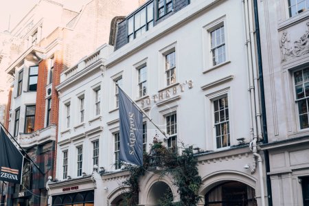 Foto de Londres, Reino Unido - 26 de diciembre de 2022: Nombre y bandera en el edificio de Sotheby 's, uno de los mayores corredores de arte fino y decorativo, joyas y objetos de colección del mundo, en New Bond Street en Londres. - Imagen libre de derechos