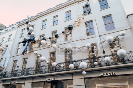 Photo for London, UK - December 26, 2022: Giant necklace Christmas decoration on the exterior of Chanel store on New Bond Street, one of the most famous streets for luxury shopping in London. - Royalty Free Image