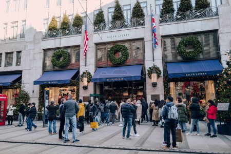 Photo for London, UK - December 26, 2022: Ralph Lauren store on New Bond Street, one of the most famous streets for luxury shopping in London, people queue outside on Boxing Day. - Royalty Free Image