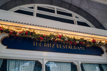 Foto de Londres, Reino Unido - 26 de diciembre de 2022: Cartel decorado festivo fuera del restaurante The Ritz, de alta gama BritánicaCena francesa en salón dorado de estilo barroco con frescos de techo y lámparas de araña. - Imagen libre de derechos