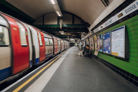 Foto de Londres, Reino Unido - 26 de diciembre de 2022: Plataforma de la estación Goodge Street del metro de Londres, el tren subterráneo más antiguo del mundo, tren que llega borroso. - Imagen libre de derechos