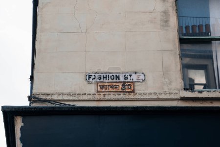 Foto de Cartel bilingüe inglés y bengalí en un edificio de Fashion Street en Spitalfields, East London, Reino Unido. - Imagen libre de derechos