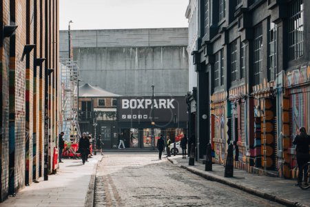 Foto de London, UK - February 09, 2023: View of Boxpark Shoreditch, a shipping container mall for independent fashion and lifestyle stores and cafes, from a nearby street, selective focus on the background. - Imagen libre de derechos