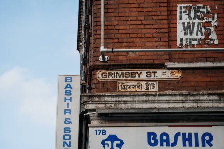 Foto de Londres, Reino Unido - 09 de febrero de 2023: Cartel bilingüe inglés y bengalí con el nombre de la calle en un edificio en Grimsby Street cerca de Brick Lane, el corazón de la comunidad Londons Bangladesh-Sylheti. - Imagen libre de derechos