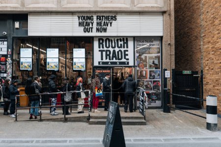 Téléchargez les photos : Londres, Royaume-Uni - février 09, 2023 : Facade of Rough Trade music shop inside old brewery with a coffee shop that also sells books and hosts in-store concerts, in Brick Lane, East London, people queue outside. - en image libre de droit
