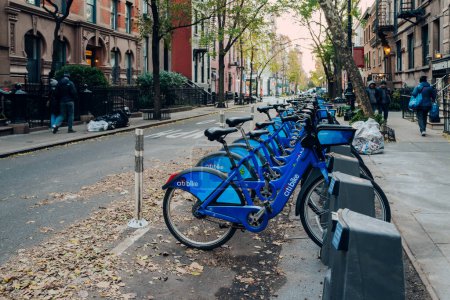 Foto de New York, USA - November 22, 2022: Row of Citi Bikes parked at the docks on a street in Manhattan, New York. Citi Bike is a privately owned public bicycle sharing system serving the city. - Imagen libre de derechos