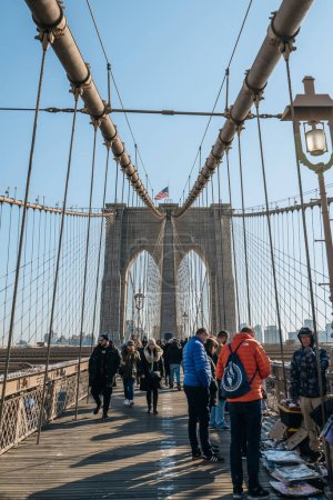 Téléchargez les photos : New York, États-Unis - 21 novembre 2022 : Les gens achètent des souvenirs auprès de vendeurs sur Brooklyn Bridge, un célèbre pont hybride suspendu par câble à New York, par une journée ensoleillée d'hiver. - en image libre de droit