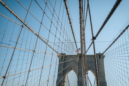 Téléchargez les photos : View of Brooklyn Bridge, a famous hybrid cable-stayed-suspension bridge in New York City, on a sunny winter day against blue sky. - en image libre de droit