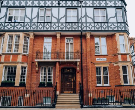 Foto de Londres, Reino Unido - 21 de febrero de 2023: Exterior o un edificio de ladrillo rojo con estilo Tudor en Hans Crescent en Kensington y Chelsea, una zona opulenta del oeste de Londres favorecida por celebridades. - Imagen libre de derechos