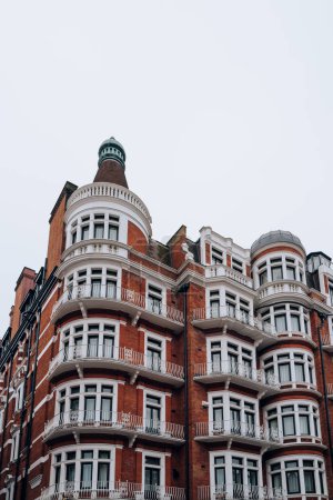 Foto de Tradicional bloque de apartamentos de ladrillo rojo con marcos de ventanas blancas en Kensington y Chelsea, Londres, Reino Unido. - Imagen libre de derechos