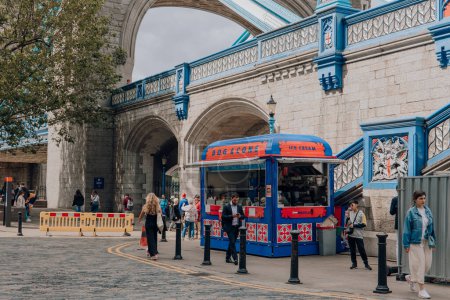 Téléchargez les photos : Londres, Royaume-Uni - 06 juillet 2023 : Le stand de crème glacée et hot-dog Dog and Cone au bord de la Tamise près du Tower Bridge, l'une des principales attractions touristiques de Londres. - en image libre de droit