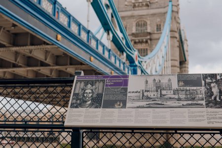 Téléchargez les photos : Londres, Royaume-Uni - 06 juillet 2023 : Panneau montrant l'histoire de la Tour de Londres, Tower Bridge en arrière-plan. Tower of London et Tower Bridge sont l'un des monuments les plus populaires de Londres. - en image libre de droit