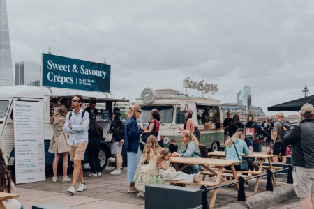 Téléchargez les photos : Londres, Royaume-Uni - 06 juillet 2023 : Les gens apprécient la nourriture des camions-restaurants sur la Tamise au bord de la Tour de Londres, l'une des principales attractions touristiques de Londres. - en image libre de droit