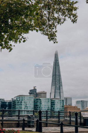 Photo for London, UK - July 06, 2023: View of South Thames riverside and The Shard through the trees on the North bank. The Shard is are one of the most popular landmarks in London. - Royalty Free Image
