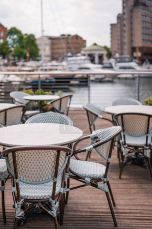 Téléchargez les photos : Tables et chaises de restaurant en plein air vides à St Katherine Dock à Londres, Royaume-Uni, objectif sélectif. - en image libre de droit
