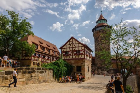 Foto de Nuremberg, Alemania - 19 de julio de 2023: Vista del histórico castillo de Nuremberg.Los turistas caminan por las calles adoquinadas del casco antiguo, Franconia, Baviera - Imagen libre de derechos