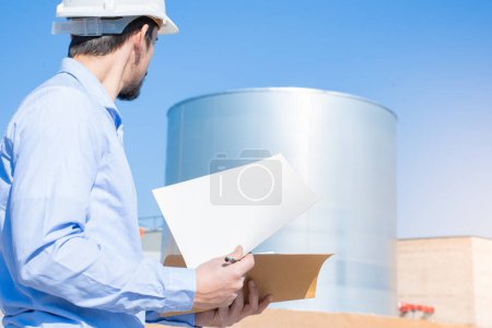 Photo for Unrecognizable civil engineer inspecting work at construction site with licenses and blueprints, standing outdoors. Inspector report and control manager. Copy space for text. High quality photo - Royalty Free Image
